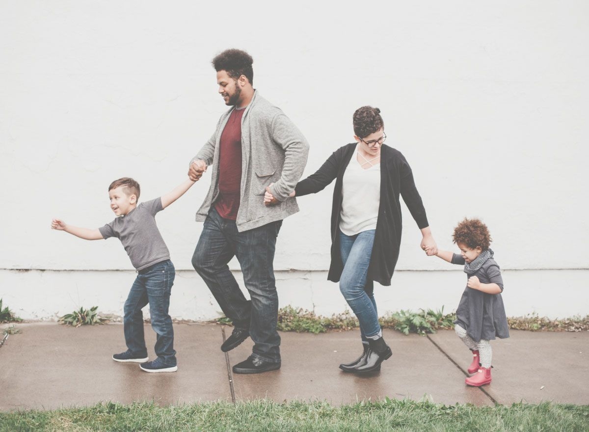 family walking on a sidewalk