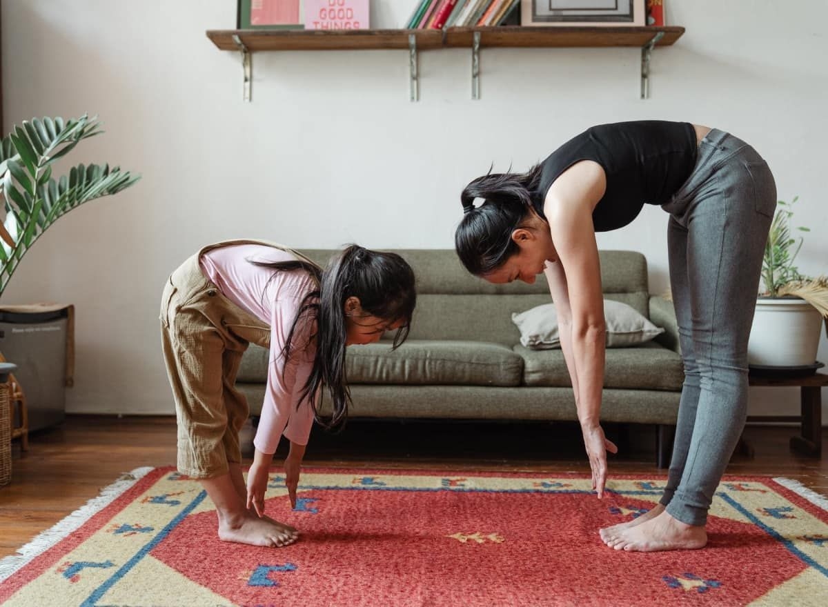 Two people stretching and reaching for feet