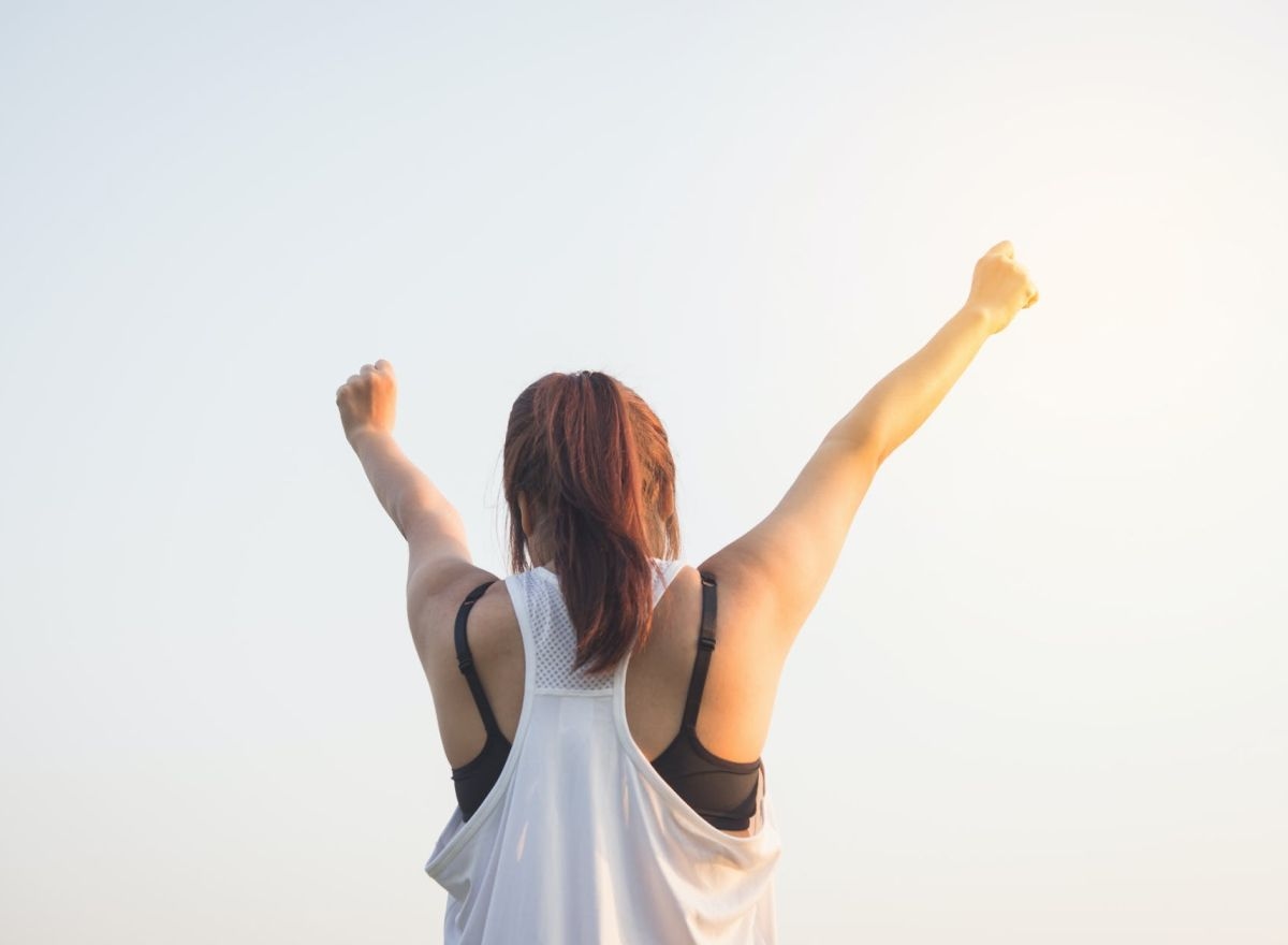 person raising arms in the air